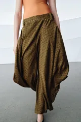 Pantalón de tiro medio confeccionado en viscosa, con diseño de pierna ancha y drapeado lateral. Presenta cintura con trabillas y cierre de cremallera oculto en la costura.