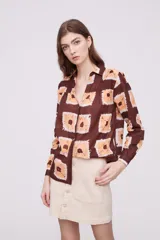 Camisa marrón con estampado de cuadrados color naranja y blanco, de corte holgado y manga larga.