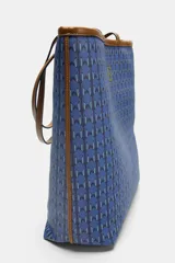 Bolso tipo tote de hombro con cuerpo estampado en tonos azules con patrón geométrico. Cuenta con detalles en tono tostado en las asas dobles, bordes y costuras en contraste. Cierre mediante botón imantado y compartimento interior.
