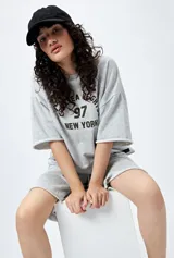 Buzo negro de corte holgado con estampado frontal que dice "Chelsea Heights 97 New York".