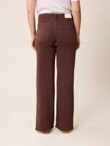 Pantalón jean de tiro alto y corte recto, color marrón chocolate, con aberturas laterales en el ruedo.