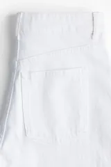 Jean de tiro alto con corte wide leg, confeccionado en denim de algodón con leve elasticidad. Presenta diseño clásico de cinco bolsillos, cierre frontal con botón y corte holgado desde el muslo hasta el bajo.