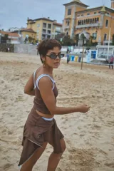 Musculosa de punto acanalado color celeste, con ribete marrón en el cuello y las sisas, y un pequeño bordado de fresa en el pecho.