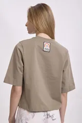 T-shirt de manga corta, color verde oliva o caqui, con cuello redondo y corte holgado.