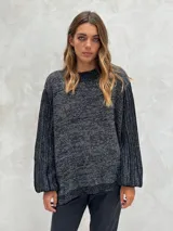 Sweater de punto color gris oscuro con hilos de lurex plateados, cuello redondo y mangas largas abullonadas con puños ajustados.