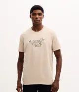 Remera de algodón color beige con cuello redondo y manga corta, con estampa frontal con el texto "Tropical Handmade".