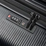 Valija de viaje grande de policarbonato color negro, con diseño texturizado de líneas verticales, esquinas reforzadas y ocho ruedas multidireccionales.