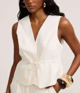 Chaleco color crudo confeccionado en viscolino con lazo y elástico en la cintura, con botones delanteros y forro.