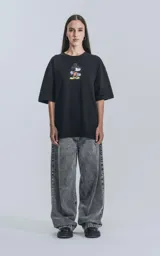 Remera oversize de algodón premium color negro, con cuello redondo y manga corta. Presenta un estampado frontal centrado de Mickey Mouse patinando.