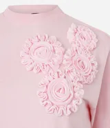 Blusa boxy de manga corta, confeccionada en algodón, con cuello redondo y detalles de flores de tejido aplicadas en el hombro y sisa.