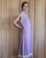 Vestido largo color lila, sin mangas, con cuello redondo y una gran estrella blanca estampada en la espalda. El cuello y el dobladillo inferior son de color beige.