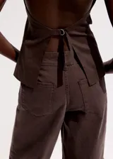 Pantalón de jean marrón con costuras frontales marcadas y corte recto.
