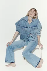 Jean de tiro alto con corte wide leg y piernas amplias. Confeccionado en denim de algodón con leve stretch, presenta diseño de cinco bolsillos, cierre con botón y bajo con detalle de ruedo desgastado.