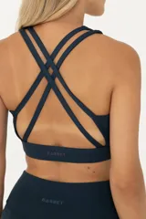 Top deportivo azul con breteles finos y tiras cruzadas en la espalda.