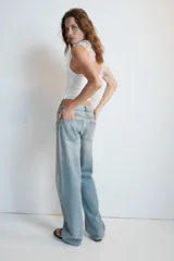 Jeans de mezclilla de tiro medio con cinco bolsillos, diseño relaxed fit de corte recto y amplio, con efecto lavado y desgaste frontal.