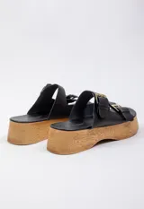 Sandalias negras de cuero con plataforma de madera y hebillas metálicas.