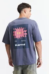 Remera de manga corta con calce oversize, confeccionada en algodón. Presenta un diseño estampado en la espalda con un gráfico abstracto y la palabra 'blurred'.