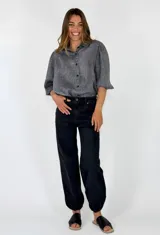 Pantalón denim de corte recto y holgado en color negro, con diseño embolsado en los tobillos y tiro medio.