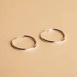 Aros tipo argolla de diseño minimalista, fabricados en plata 925 con acabado pulido.