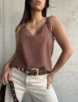 Musculosa marrón con rayas verticales blancas, escote en V y breteles con detalle de argollas.
