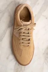 Zapatillas bajas color beige con detalles en cuero color crema.
