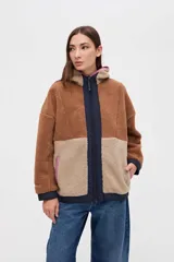 Campera de sherpa con diseño de bloques de color en tonos marrones y beige, con capucha, cierre frontal y detalles en nylon azul marino.