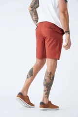 Bermuda tipo chino de gabardina, con bolsillos laterales y traseros, cierre de cremallera y botón, y pasacintos en la cintura. Presenta un diseño clásico con logo bordado.