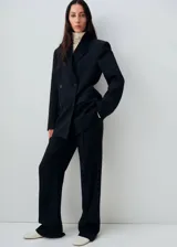 Blazer de corte recto y diseño de raya diplomática, con cuello de solapa con muesca, cierre frontal de doble botonadura y mangas largas con puños abotonados. Cuenta con forro interior y dos bolsillos de solapa en la parte frontal.