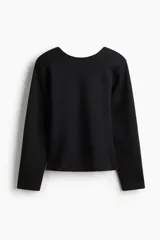 Remera de manga larga negra en tejido efecto neopreno suave, con escote redondo al frente, espalda escotada en V, hombreras y cintura entallada con bajo levemente acampanado.