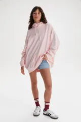 Buzo hoodie rosa con cordones blancos y bolsillo tipo canguro. Estampado frontal pequeño con el logo de Levi's en blanco y estampado grande en la manga con la frase "Endless Dreams" en letras cursivas blancas.