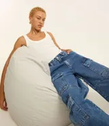 Pantalón de jean negro con corte recto, cintura alta, trabillas y bolsillos cargo laterales.