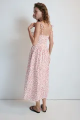 Vestido midi de popelina blanco con estampado de lunares rojos, escote corazón, tirantes finos con lazo y detalle de nudo en el busto.