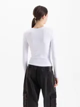Remera de micro rib color blanco, con cuello redondo, mangas largas y silueta ajustada al cuerpo. Presenta logo bordado en la espalda.