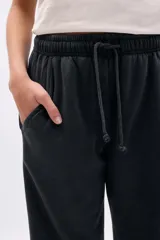 Pantalón deportivo ancho color negro con efecto lavado, cintura elástica con cordón ajustable y bolsillos laterales.