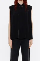 Blusa negra sin mangas de viscosa con cuello mao con lazo, pliegues en los hombros y pespuntes a contraste.
