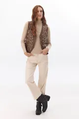 Chaleco marrón de simil cuero con bordado en color crema, cuello en V y cierre frontal con botones.