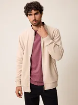Campera de polar con cierre frontal completo, cuello alto y puños elásticos. Presenta un diseño minimalista con bolsillos laterales.