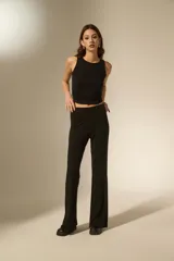 Pantalón tipo calza de tiro alto con corte flare, confeccionado en tejido de viscosa y elastano con detalles de strass dispersos.