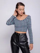 Top de tejido de punto con estampado geométrico en blanco y negro, de manga larga y cuello redondo.