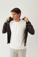 Campera tejida color verde militar, con cuello alto, cierre frontal completo, logo bordado en el pecho y rayas horizontales en blanco, marrón y azul marino.