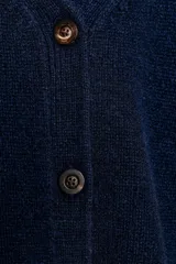 Chaqueta tipo cárdigan de lana color azul marino, con cuello en pico, cierre frontal de botones y mangas abullonadas de largo tres cuartos.