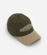 Gorra de sarga de algodón en color verde oliva con visera en tono beige. Presenta un bordado frontal con la palabra Expedition y detalles de texto en color crema.