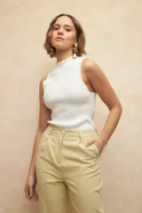 Pantalón de vestir color crema, de corte recto, con bolsillos laterales y traseros. Se ajusta a la cintura con dos botones.