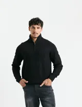 Sweater de punto inglés color verde, con cuello alto y cierre frontal parcial metálico. Diseño de manga larga con puños y ruedo acanalados.