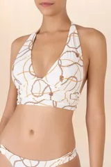 Top de traje de baño halter blanco con estampado de cadenas doradas y marrones, con faja amplia que realza el escote. Se ata al cuello y a la espalda con tiras anchas.