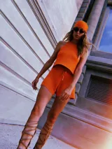 Blusa de punto color beige con lurex, modelo halter y diseño acanalado.