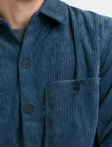 Sobrecamisa de pana color marrón, con manga larga, cierre frontal con botones y dos bolsillos frontales con solapa y botón.