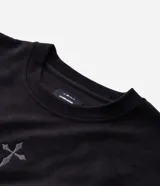Remera masculina oversize de tejido tipo gamuza sintética (suede) de color negro, con cuello redondo, mangas cortas y detalle de bordado de cruz en el frente.