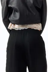 Pantalón de corte holgado en tejido liviano de mezcla de lino, con tiro alto, cintura elástica y cordón ajustable, bolsillos laterales y piernas rectas.