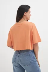 Remera color beige de corte cropped y mangas cortas.